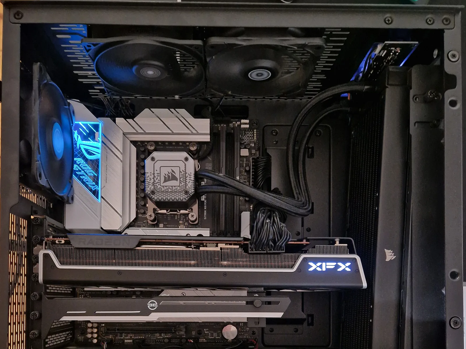Geöffneter Gaming-PC mit ASUS-ROG-Strix-Mainboard, Corsair-Wasserkühlung und XFX-Radeon-Grafikkarte